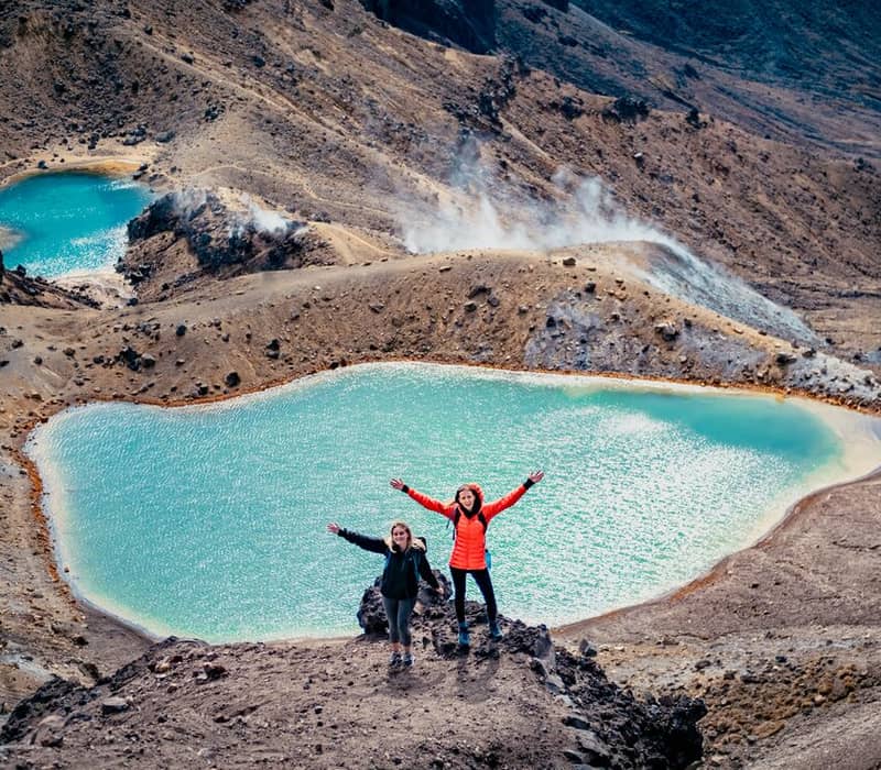 Hikers at Emerald Lakes in New Zealand's volcanic landscape.