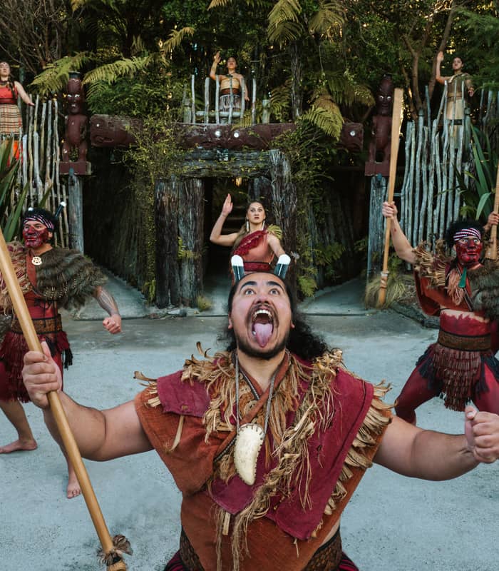 Maori kapa haka group performing traditional dance with spears and face paint in forest setting. Credit: Te Pa Tu