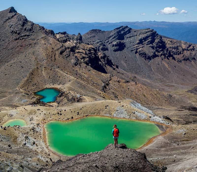 Hiker overlooks emerald lakes in Tongariro National Park, New Zealand. Credit: Intrepid Travel