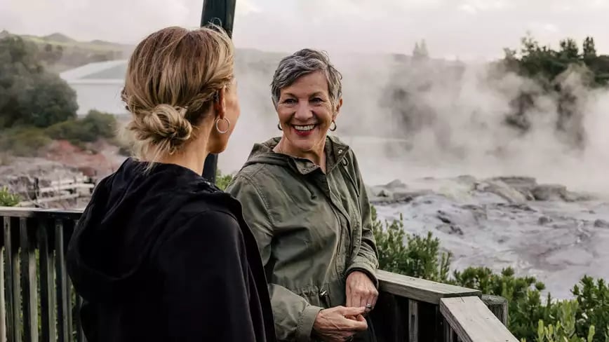 Two women enjoying the view of steaming geysers in Rotorua.