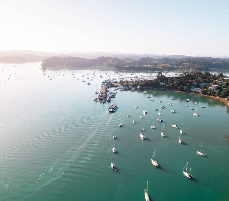 Aerial view of boats in a harbour in the Bay of Islands near a coastal town.
