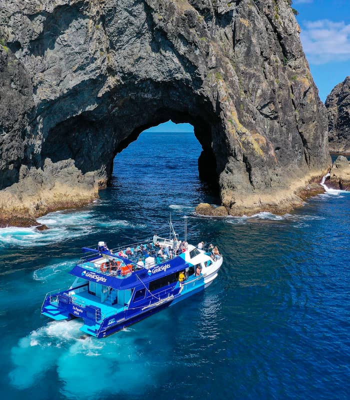 Tour boat passing through the Hole in the Rock in the Bay of Islands.