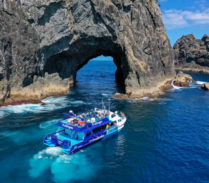 Tour boat passing through the Hole in the Rock in the Bay of Islands.