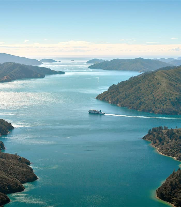 Aerial view of a ship sailing through green islands and blue waters in Marlborough Sounds. Credit: Interislander